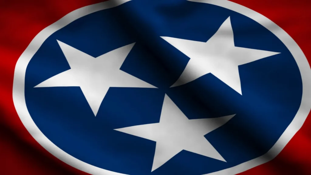 A waving state flag of Tennessee featuring three white stars inside a blue circle with a white border on a red background