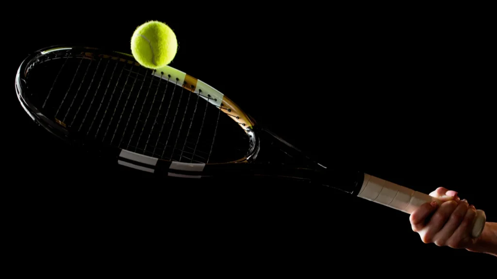 Focus shot of a tennis racket and a ball